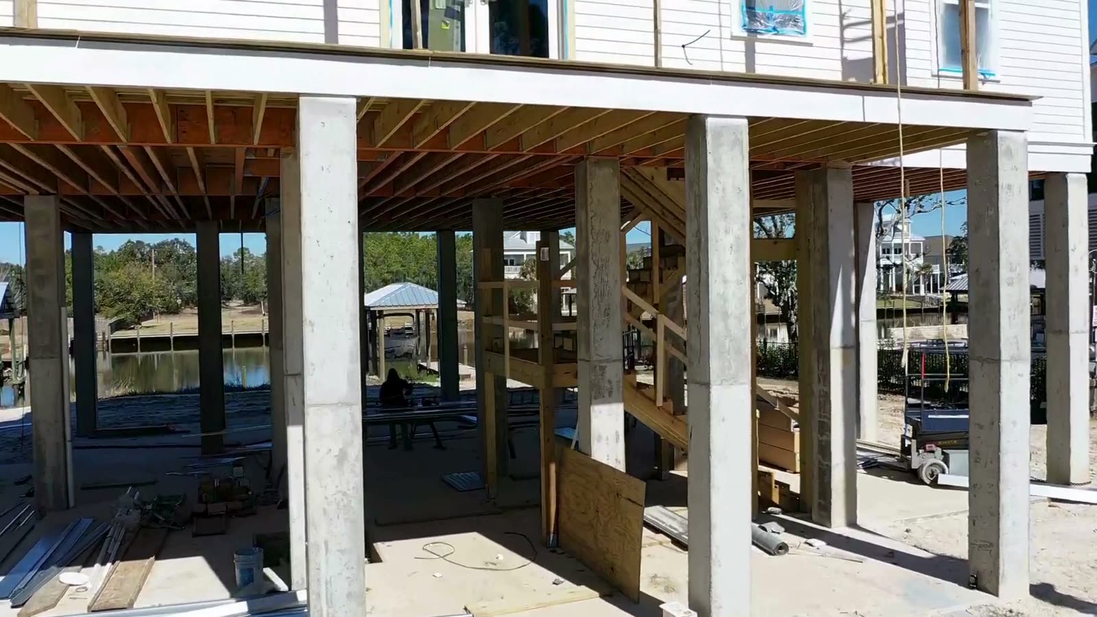 Drone view of a Gulf South Roofing crew installing a standing seam metal roof on a waterfront Mississippi Gulf Coast home