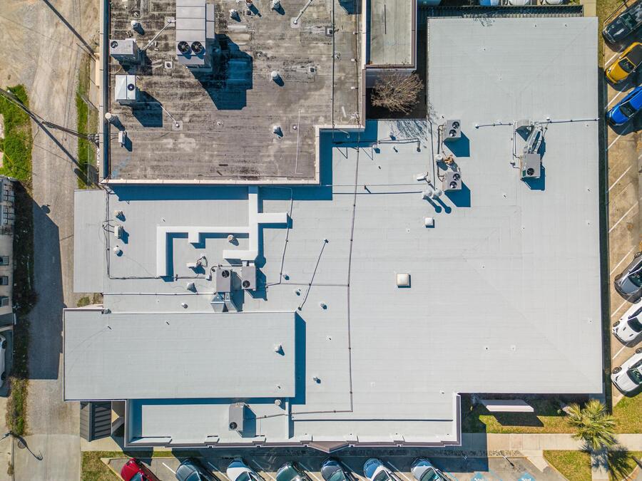 Aerial view of a low-slope commercial roof system on a Gulfport retail building
